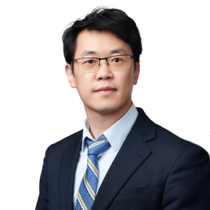 Asian man with short dark hair and glasses wearing a tie and suit jacket.