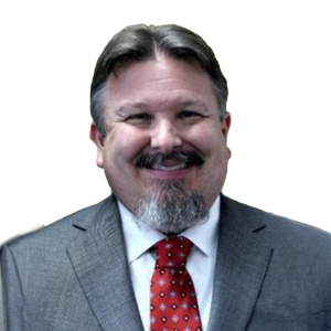 Mature white man with gray hair and beard wearing a red tie and gray suit jacket.