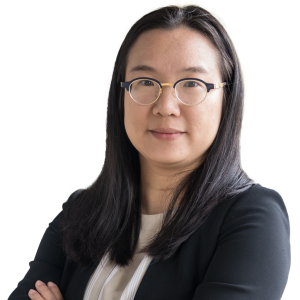 Mature asian woman with long straight dark hair and glasses wearing a black jacket and white shirt.