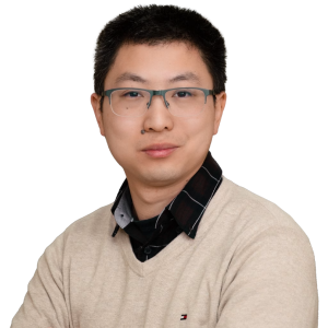 Asian man with short dark hair wearing glasses and a tan sweater with a black colored shirt underneath.