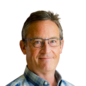 White man with short brown/gray hair wearing glasses and a blue and brown button-down shirt.