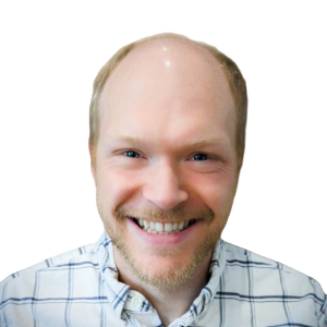 White man with no hair on the top and a little blond hair on the sides, wearing a white and blue plaid button-down shirt.