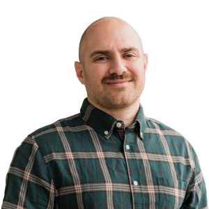 White man with no hair wearing a green and gold plaid shirt.