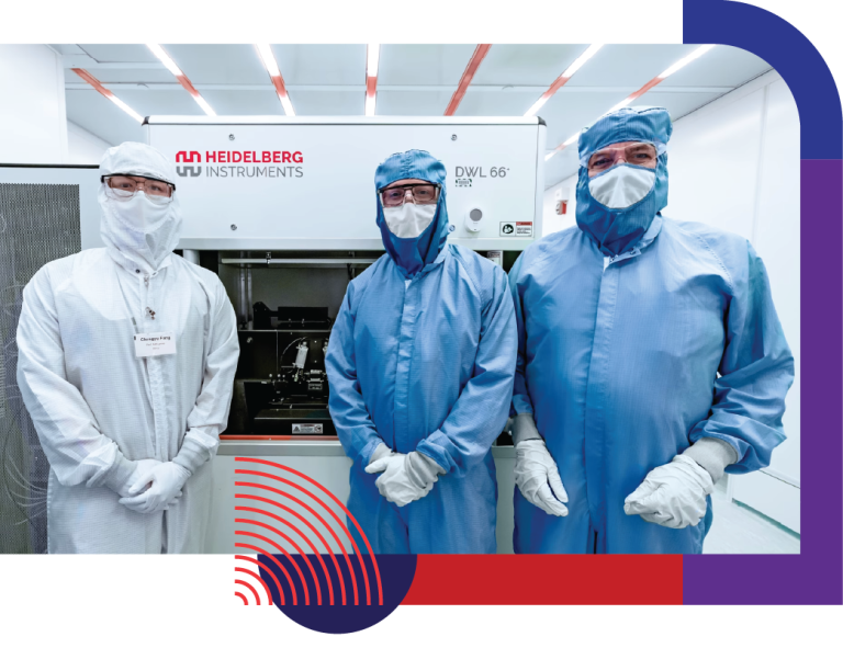 Three men in a clean room wearing masks standing in front of Heidelberg Instrument in the Nanoscale Science and Engineering Center lab at the university of wisconsin-madison.