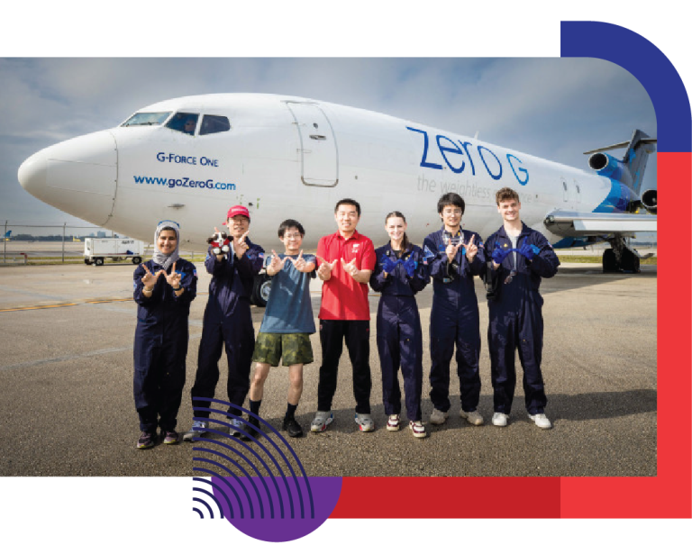 Group of students and professor using their hands to make a W standing in front of a Zero G airplane