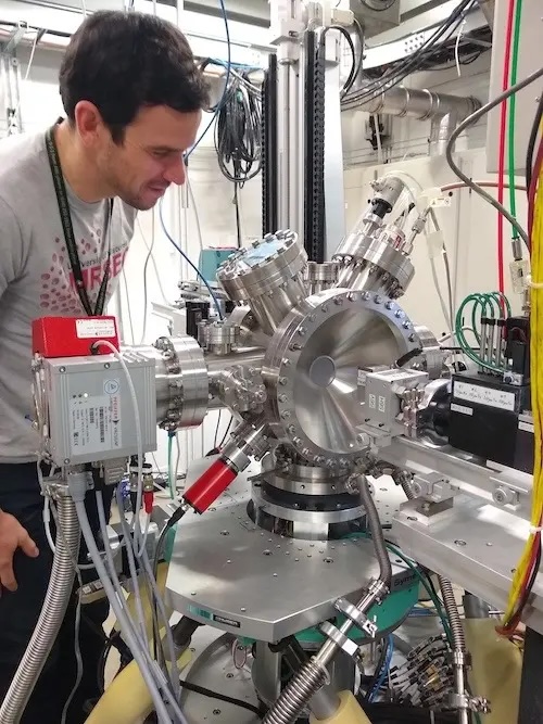 Person leans over a large piece of silver technological equipment