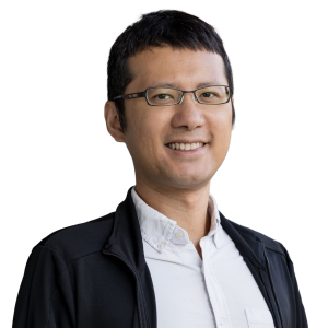 Asian man with short black hair wearing glasses and white button up shirt with a black jacket.
