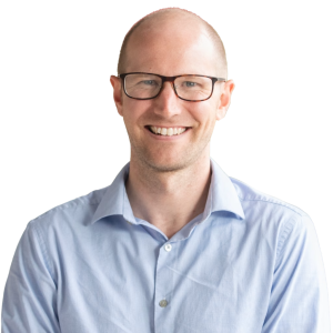White man with minimal hair wearing glasses and a light blue button down shirt.