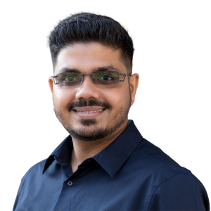 Middle eastern man with short black hair who is wearing glasses and a blue button up shirt.