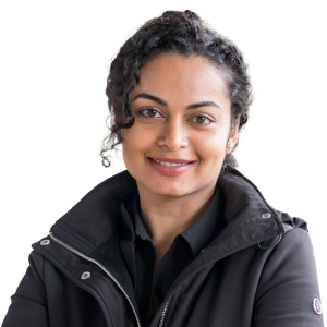 Indian woman with curly black hair wearing a black jacket.