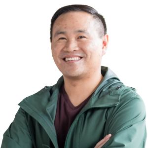 Asian man with short black hair wearing a gray shirt and green jacket.