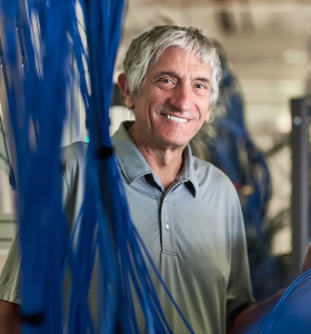 white man with short gray hair stands amongst blue wires