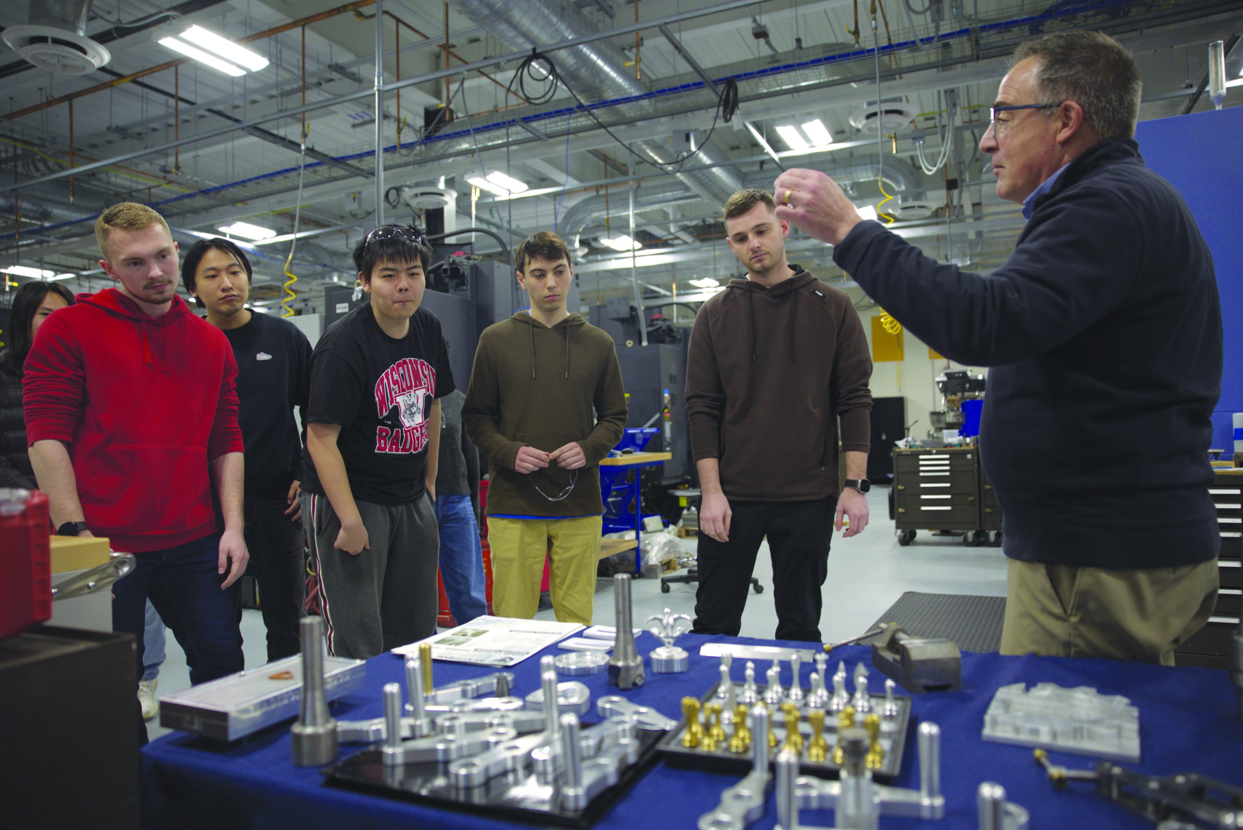 a professor instructs a group of students in a workshop setting
