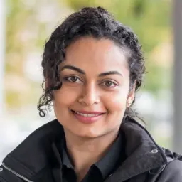 headshot of a south asian woman with long curly hair pulled back