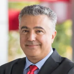 headshot of a man with tan skin and short grey hair