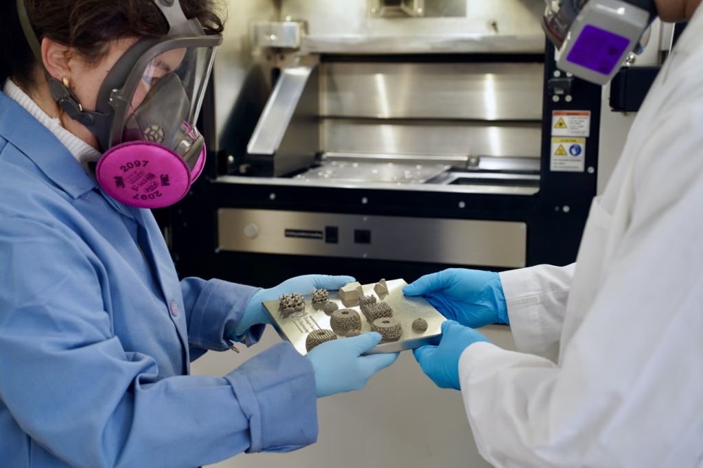 two people holding a 3D printed metal sheet between their hands