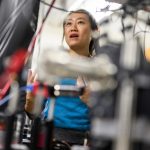 woman looking through wires on large equipment