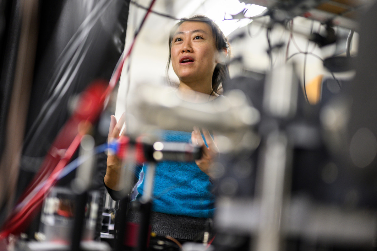 woman looking through wires on large equipment